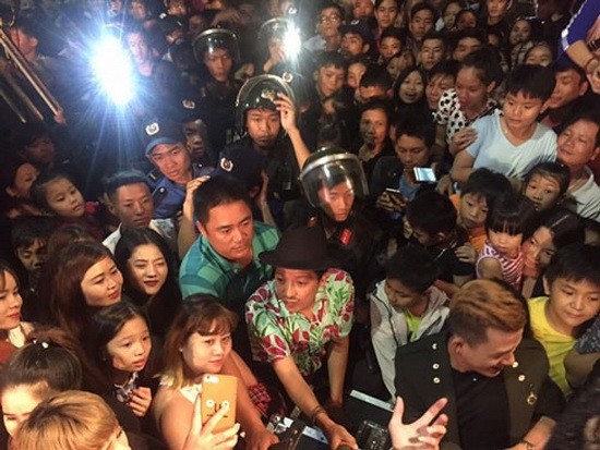 觀眾在一表演場所圍住喜劇演員長江。