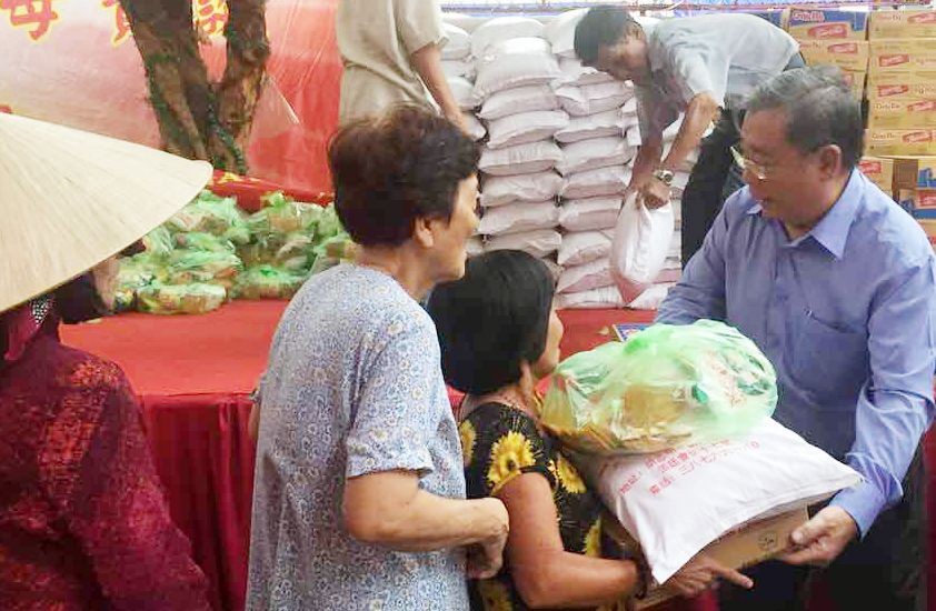 崇正會館理事長鄭鑫發向貧戶贈送禮物。