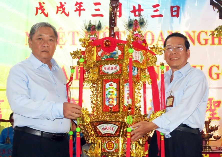 崇正會館理事長鄭鑫發(左)把第一盞 聖燈交給陳添祥先生。