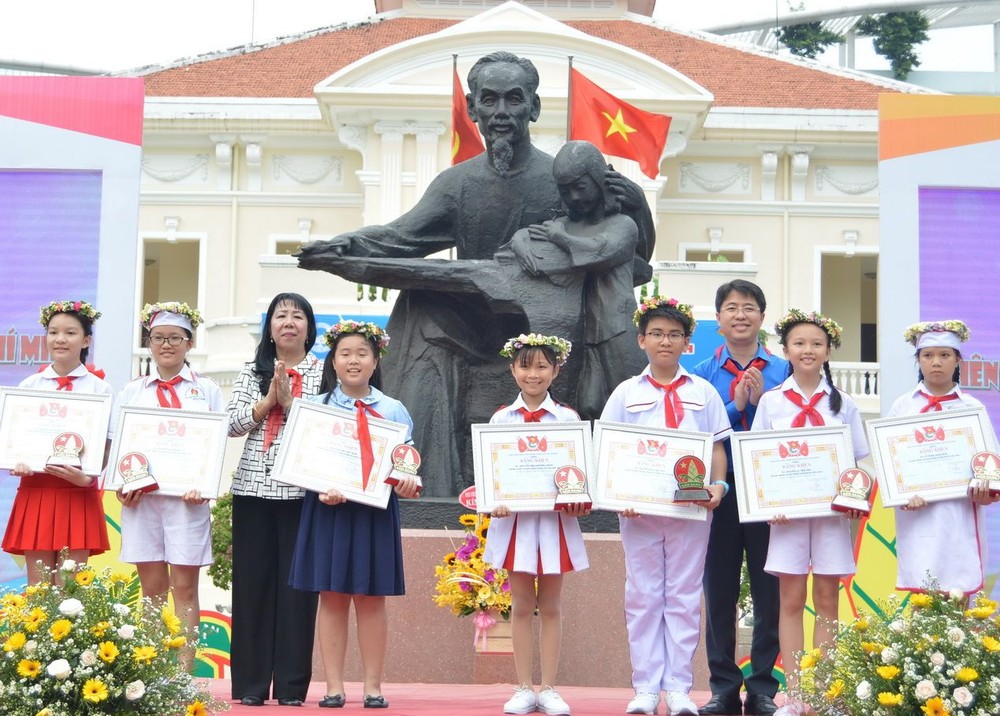 施氏雪絨主任(左三)與范鴻山書記向傑出少先隊長頒發獎狀。