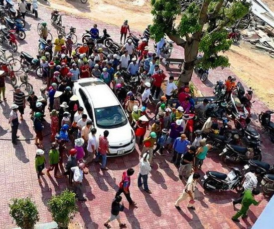 數十人圍繞著汽車上的一對男女，誤認他們倆企圖綁架當地兒童。（圖源：德英）