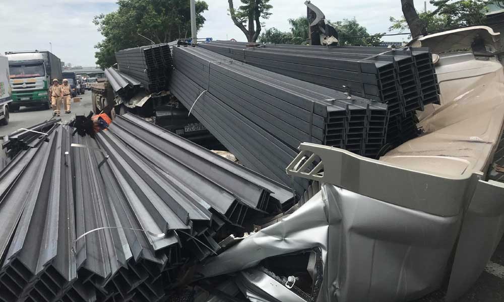 故事現場駕駛室距離集裝箱車體約4米，被上百根鋼條壓住，司機被困在駕駛室內，多束鋼條墜落路上。（圖源：越南快訊）