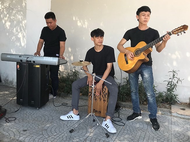在峴港市人行道上表演音樂的大學生小組。
