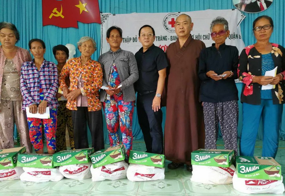 釋慧功法師（右三）和華人企業家麥漢強（右四）贈送禮物給視障者。