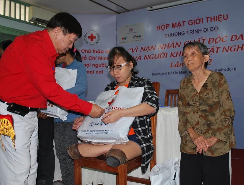 市紅十字會副主席張子諒向落葉劑受 害者和貧困殘疾人士贈送禮物。