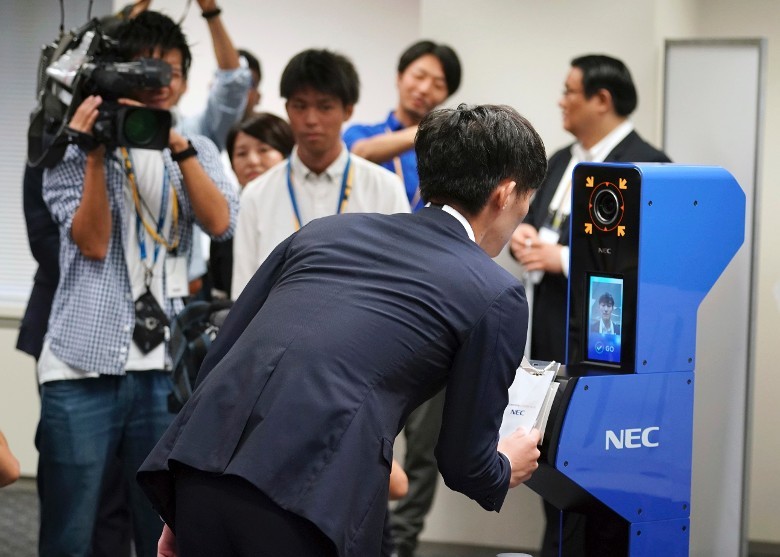 工作人員示範使用ID卡及人臉識別技術。（圖源：AP）