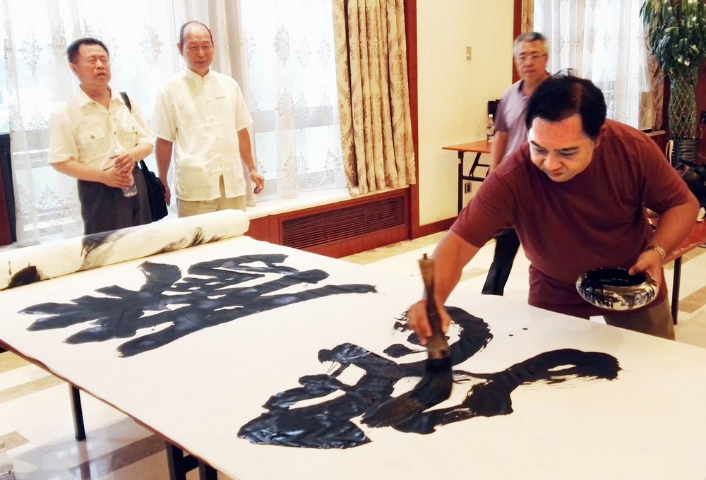 林漢城在百米長卷即席揮毫“騰飛”二字。