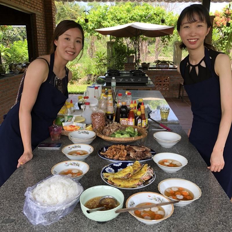 遊客(右)與屋主一同烹煮當地的傳統美食。