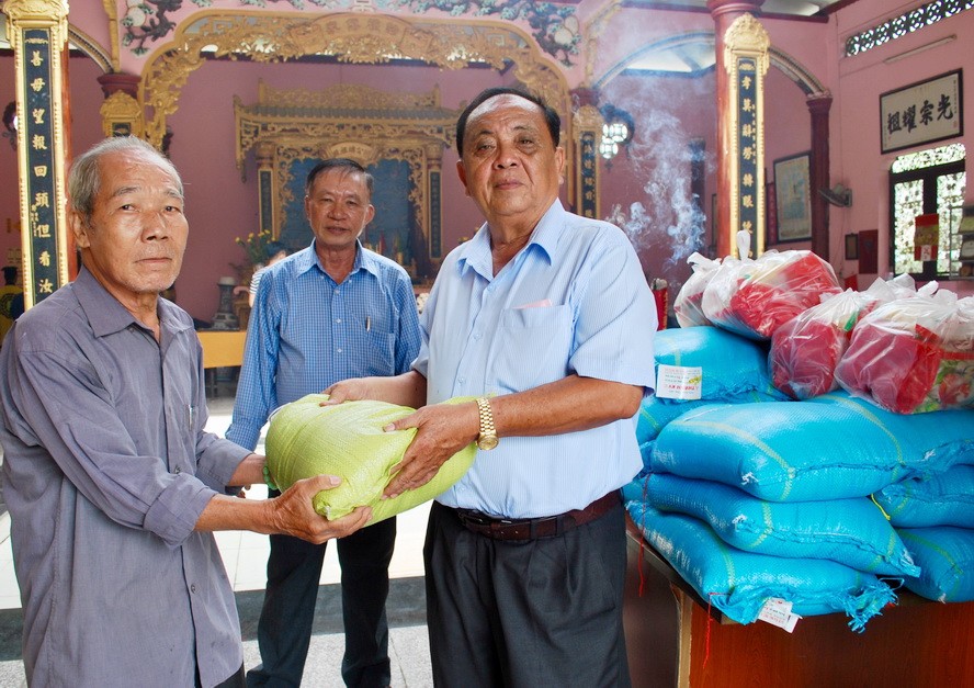 鄭氏宗祠榮譽理事長鄭紹明（右）向宗親派發盂蘭節禮物。
