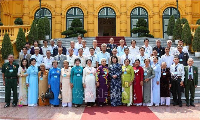 國家副主席鄧氏玉盛同永隆省革命有功者代表團在主席府前合影留念。（圖源：越通社）