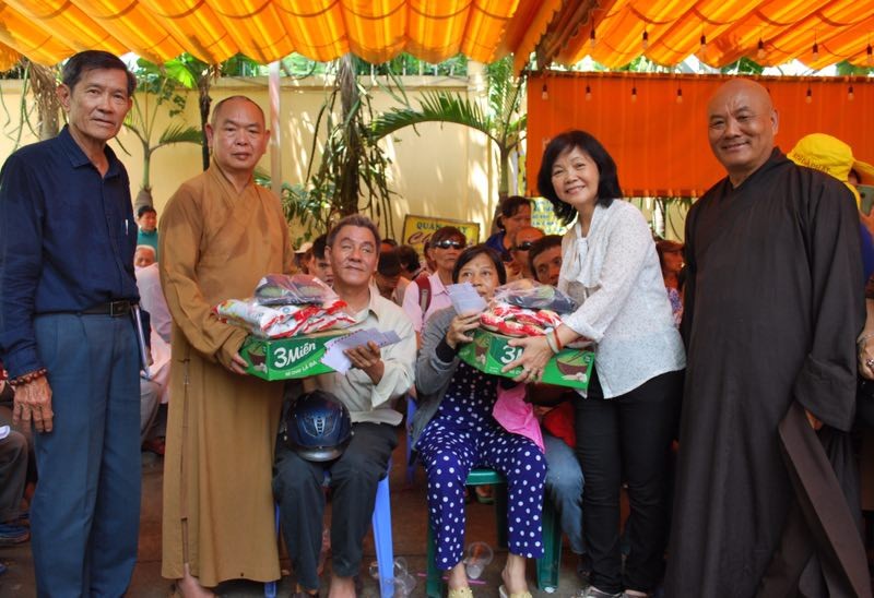 龍華寺住持釋慧功（左二）向窮人派發禮物。
