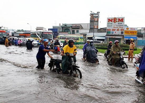 昨晨大雨又潮汛，導致本市多條街道嚴重水淹及堵車。圖為平新郡安樂環島區域嚴重受淹，許多機車引擎死火，交通堵塞綿延上千米長。（圖源：VOV）