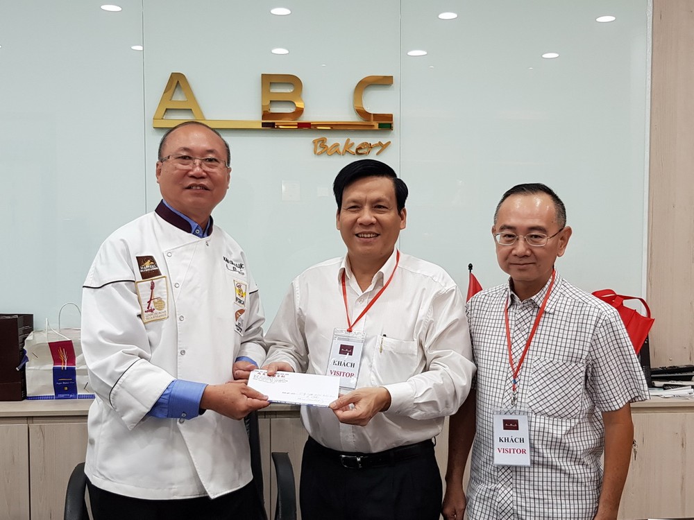 高肇力總經理（左）把贈報款項交給本報主編。