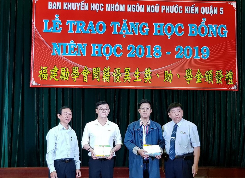 市民族處副主任梁鴻德（左一）與溫陵會館理事長 張子諒（右一）頒發獎學金給碩士生。