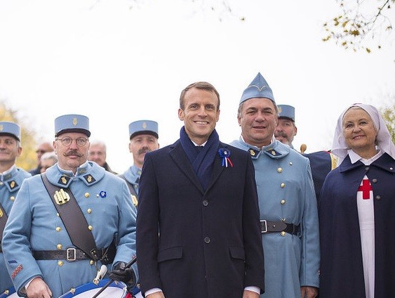 11月5日，法國莫朗格，法國總統馬克龍在當地的戰爭紀念館與身穿復古軍裝裝扮成一戰法國士兵的歷史愛好者合影。莫朗格戰爭紀念館當日舉行致敬儀式，慶祝第一次世界大戰結束一百週年。（圖源：互聯網）