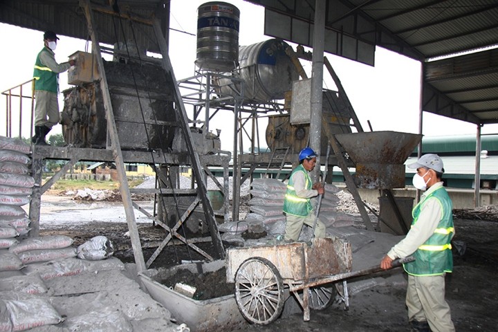 勞工將工業垃圾再製造成建材的原料。