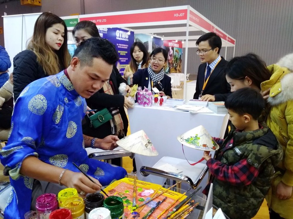 參展者觀看越南斗笠繪畫作品。