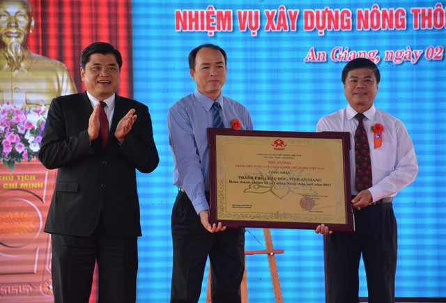 農業與農村發展部副部長陳清南（左一）向朱篤市領導轉授政府總理有關朱篤市完成建設新農村任務公認證書《決定》。（圖源：阮行）