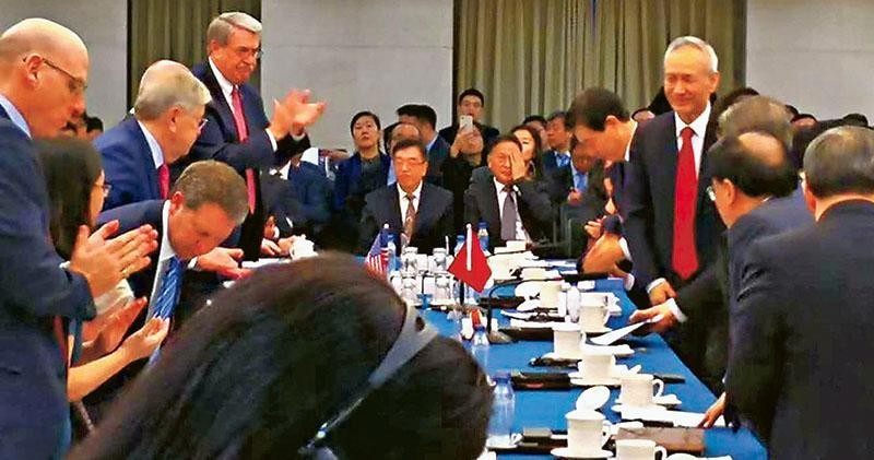 在社交網站Twitter流出的會場照片顯示，談判前的氣氛相當融洽，副總理劉鶴（右方紅領帶者）現身會場，面露笑容站在談判桌前，美方則有成員鼓掌歡迎。（圖源：互聯網）