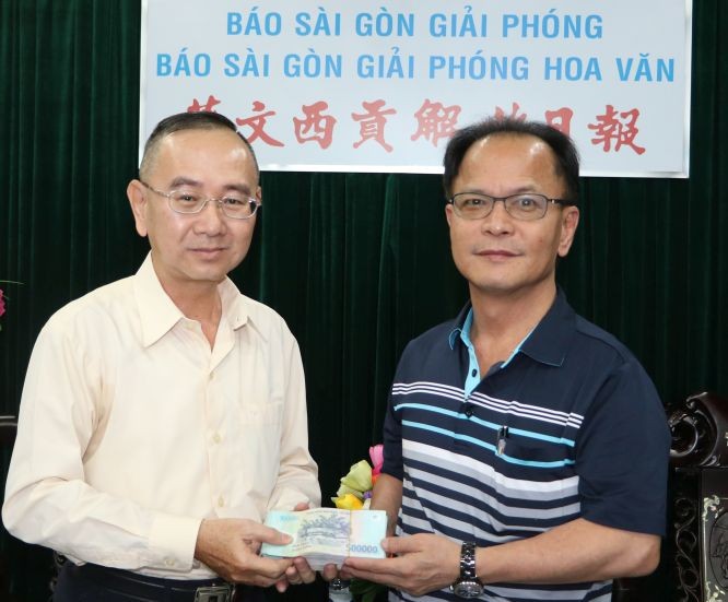 范興主任（左）接受鄭文忠會長捐款。