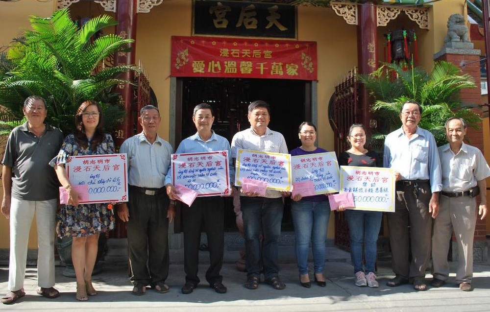 浸石天后宮副理事長張興盛(右二)與諸 位理事代表向各受惠單位轉交春節濟貧善款。