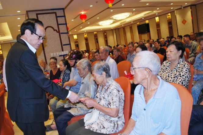 萬盛發集團代表張豐裕向貧困同胞贈送禮物。