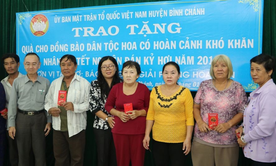 范興主任與許氏芳紅副主席向華人貧困戶贈送利是。