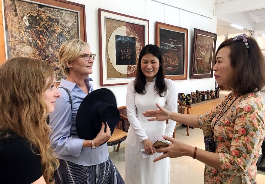 本市畫家向外賓介紹畫展。