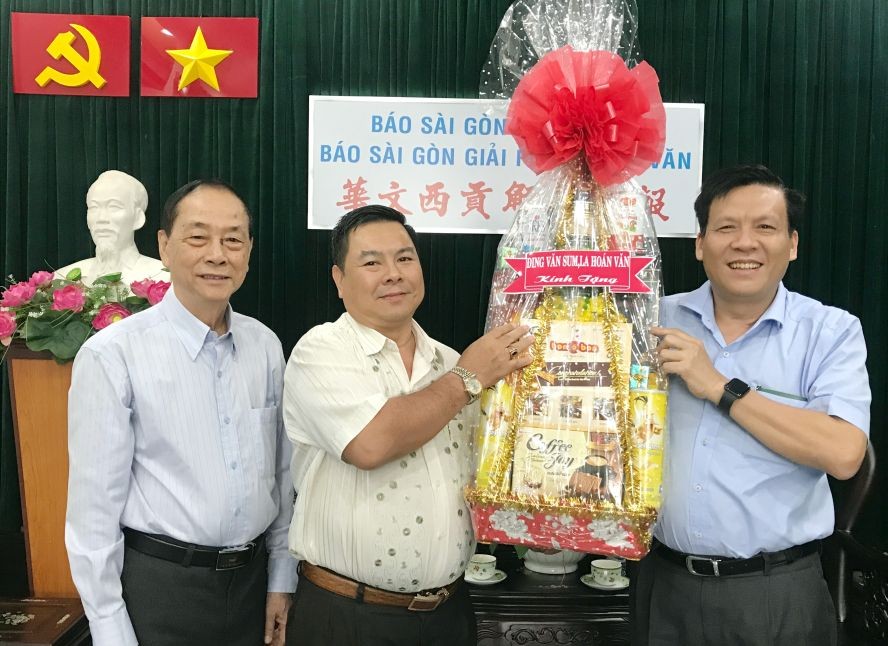 丁文森(左二)和羅煥民(左一)向本報賀年。