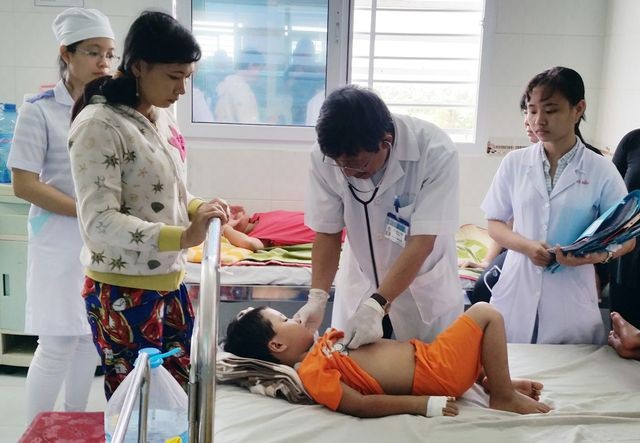 醫生在為患登革熱病童診斷。（圖源：阮行）