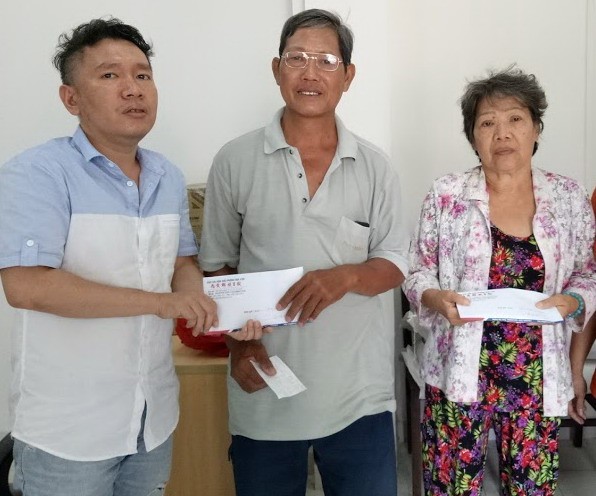 本報慈善組人員將讀者樂捐善款轉交予貧病華人。