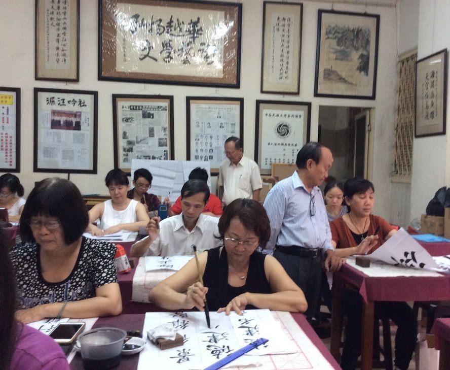 張路書畫家正在教學生練習書法。