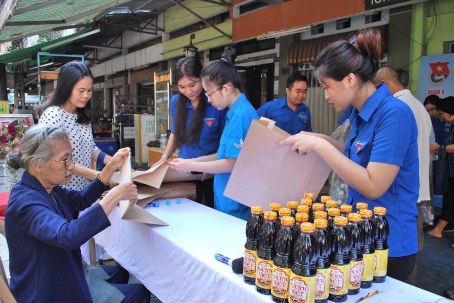 第五郡青年向民眾指引摺紙袋提高環保意識。