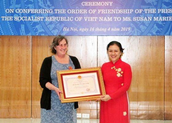 駐越南的戰爭遺產項目組織(WLP)創始人兼項目經理蘇珊‧瑪麗‧哈蒙德（左）從越南各友好組織聯合會(VUFO)主席阮芳娥手中接過獎狀。（圖源：越通社）