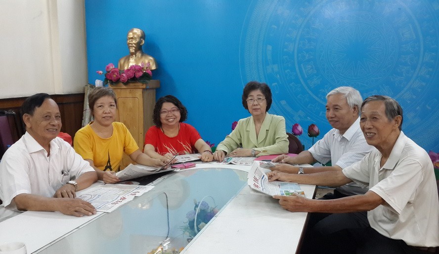 市各少數民族文學藝術協會主席劉金華（右三）與同事閱讀本報新聞。