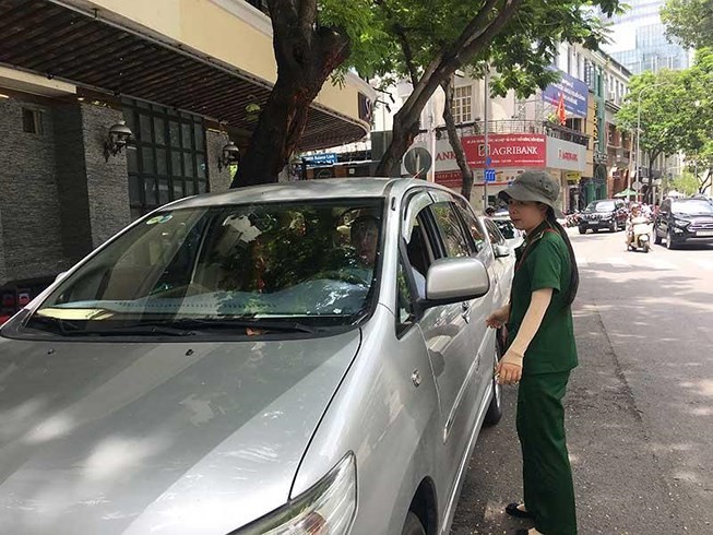 一名市青年突擊隊員指引司機在第一郡吳德計街停車。