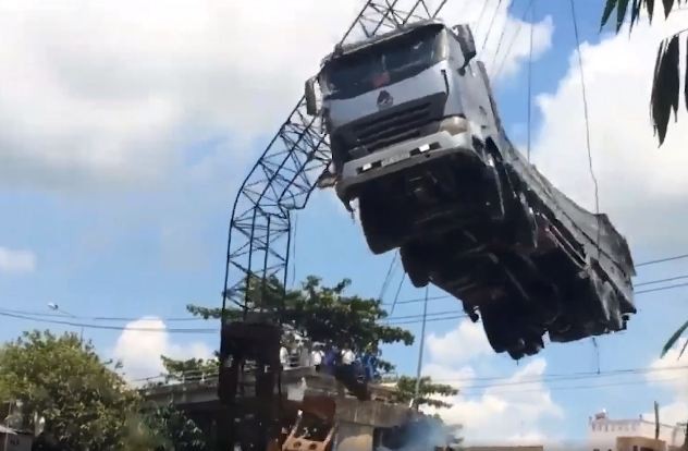 起重機吊起卡車時吊臂突然彎折的一剎那畫面。（圖源：視頻截圖）
