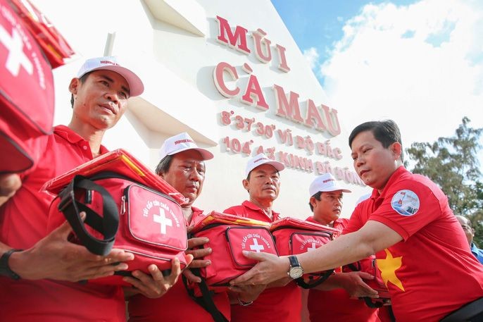 《勞動者報》總編輯蘇廷遵（右一）向模範漁民移交國旗。（圖源：黃潮）