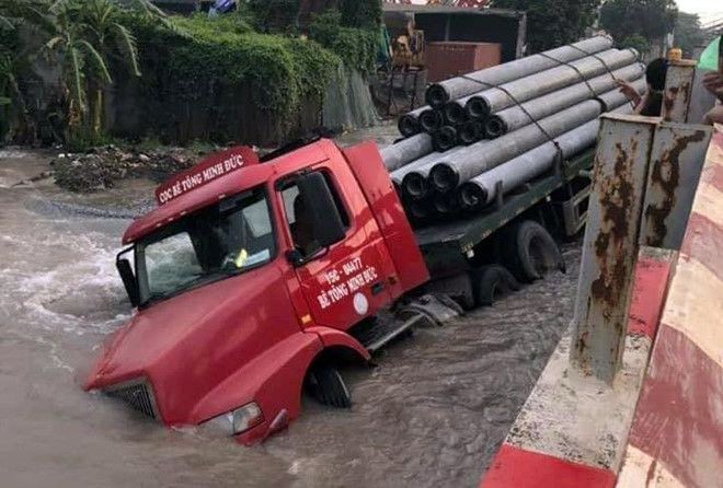 牽引車陷入路面塌陷的深水坑，坑水高漲淹沒部分車身。（圖源：Oto+）