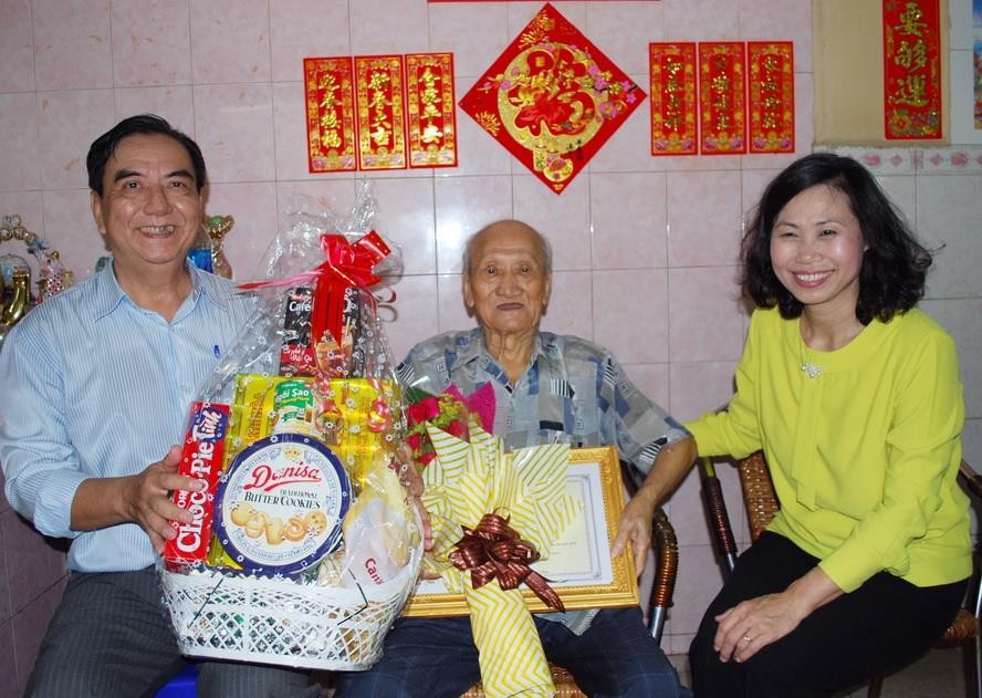 第十一郡人委會主席陳氏碧蓮（右）和郡高齡人會主席朱杞文（左）向華人長者蕭德鈞大叔贈送禮物。