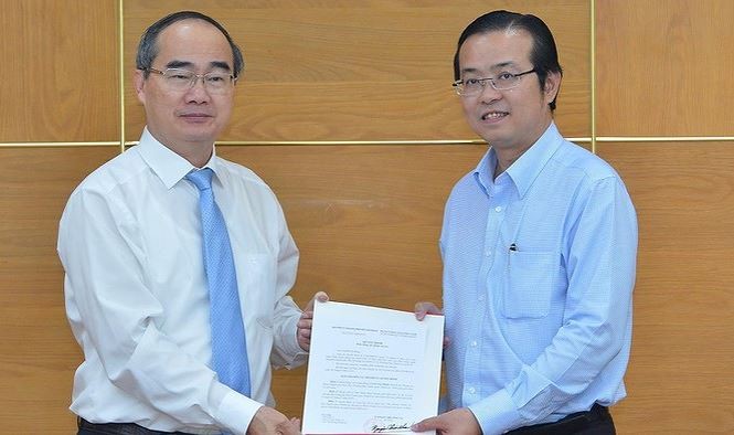 黎文明同志（右）從市委書記阮善仁手中接過調動和委任《決定》。（圖源：越勇）