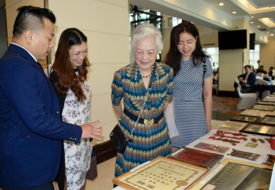 麒麟(左一)向華人同胞介紹其收藏的老堤岸事物。