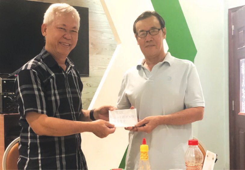 徐有燦（左）報效本報社會慈善金予本報代表接領。