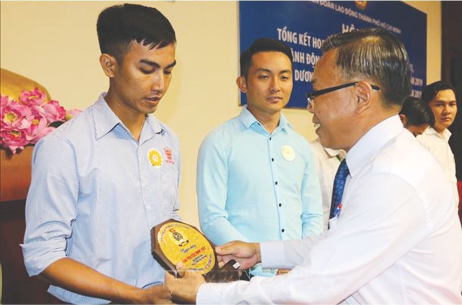 市委民運處主任阮友協向出色勞動者頒發紀念章。（圖源：互聯網）