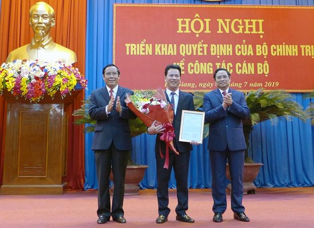 新任河江省委書記鄧國慶（中）接過人事委任《決定》和鮮花祝賀。（圖源：河江報）