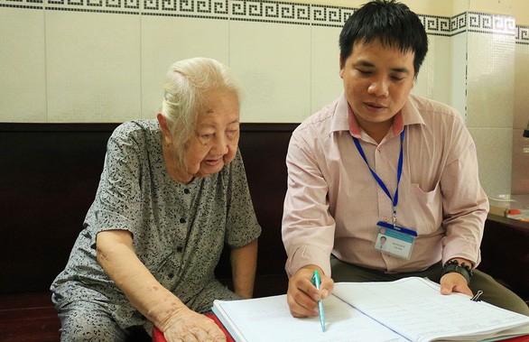 新平郡第七坊人委會司法幹部指引老人家寫授權書代領退休金。