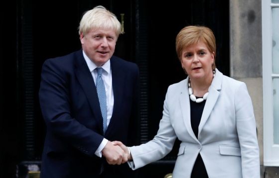 蘇格蘭政府首席大臣斯特金（右）與約翰遜握手時木無表情。（圖源：AP）