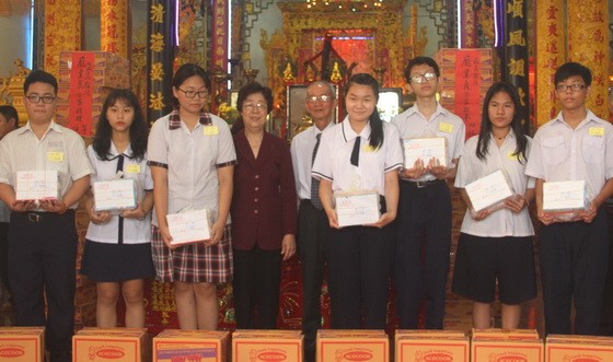 市各少數民族文學藝術協會主席劉金華及該 會館常務副理事長陳健智向瓊裔子弟頒獎。