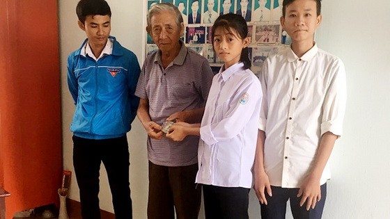 拾金不昧的兩高中生阮氏草（右二）和陳國孝（右一）將拾到的錢款交還失主。（圖源：新琪）