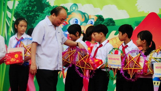 政府總理阮春福向廣南省大祿縣清貧少兒贈送中秋節禮物。（圖源：霸勇）